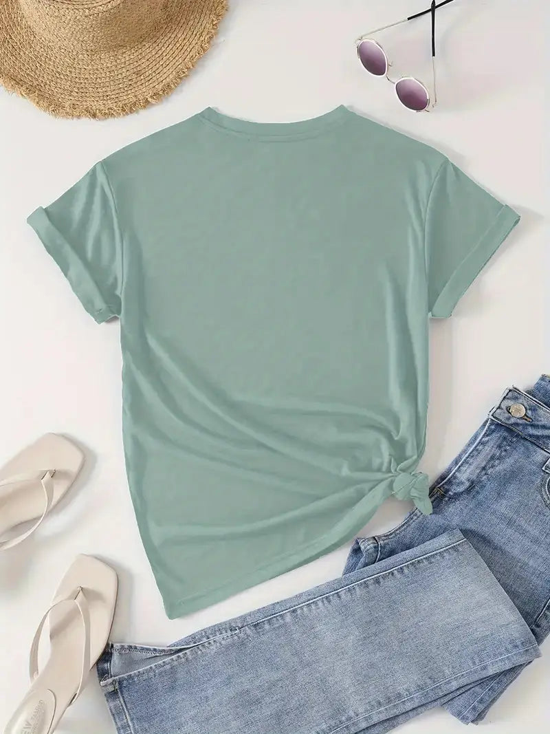 Mint green t-shirt with a knot detail, paired with denim jeans and a straw hat on a light background.