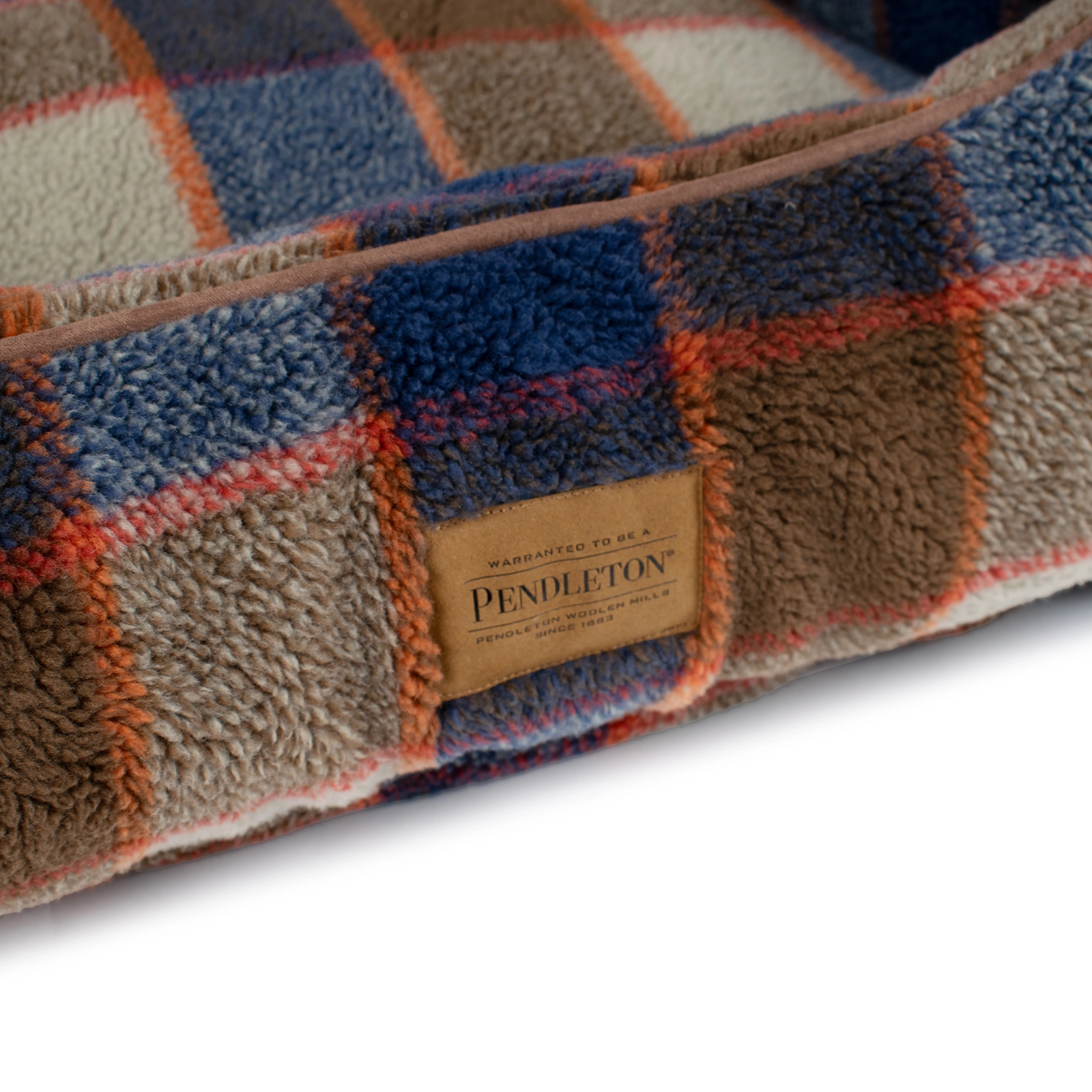 Pendleton plaid bed with brand label on a white background