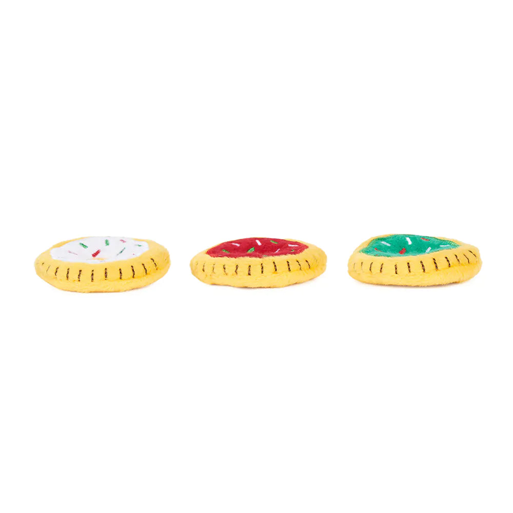 Three colorful dog toys shaped like pizzas on a white background