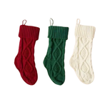 Three knitted Christmas stockings in red, green, and white on a white background.