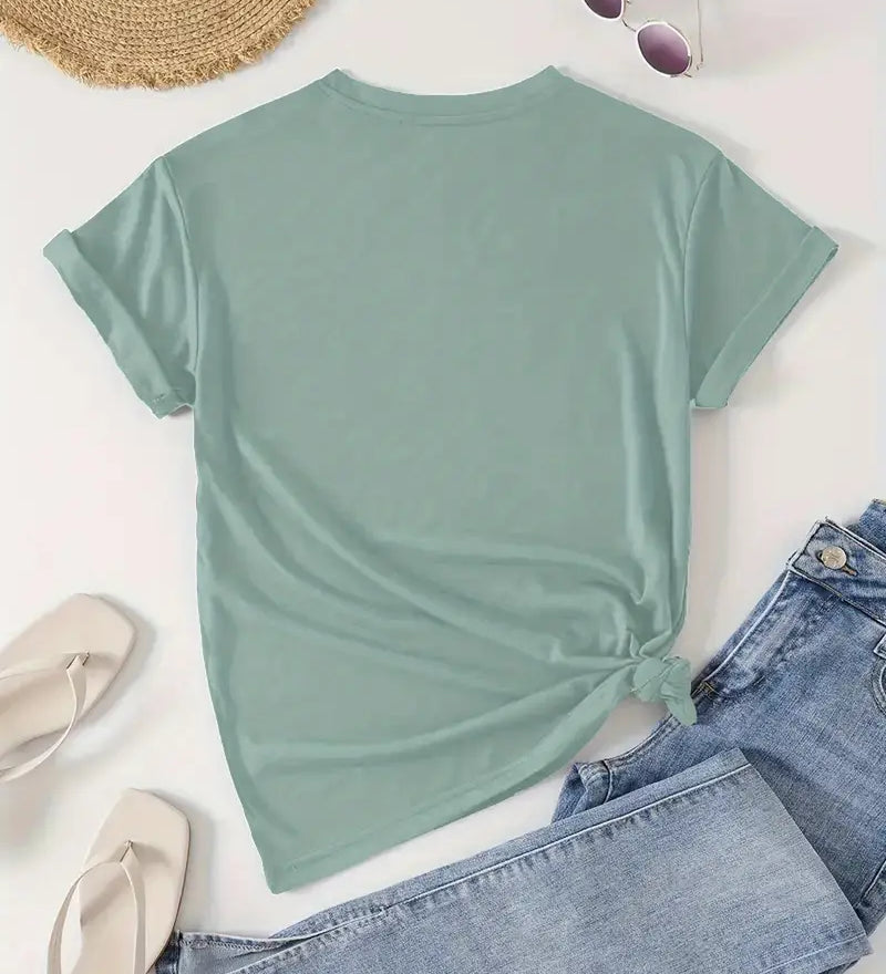Mint green t-shirt with a knot detail, paired with denim jeans and a straw hat on a light background.