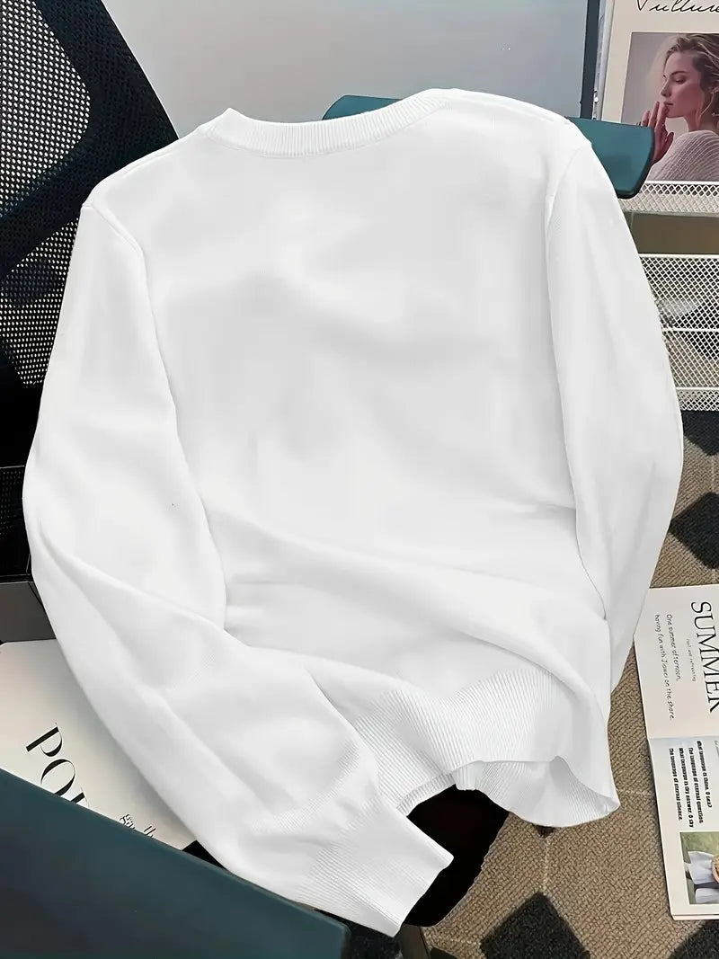 White sweatshirt on a chair with a magazine underneath