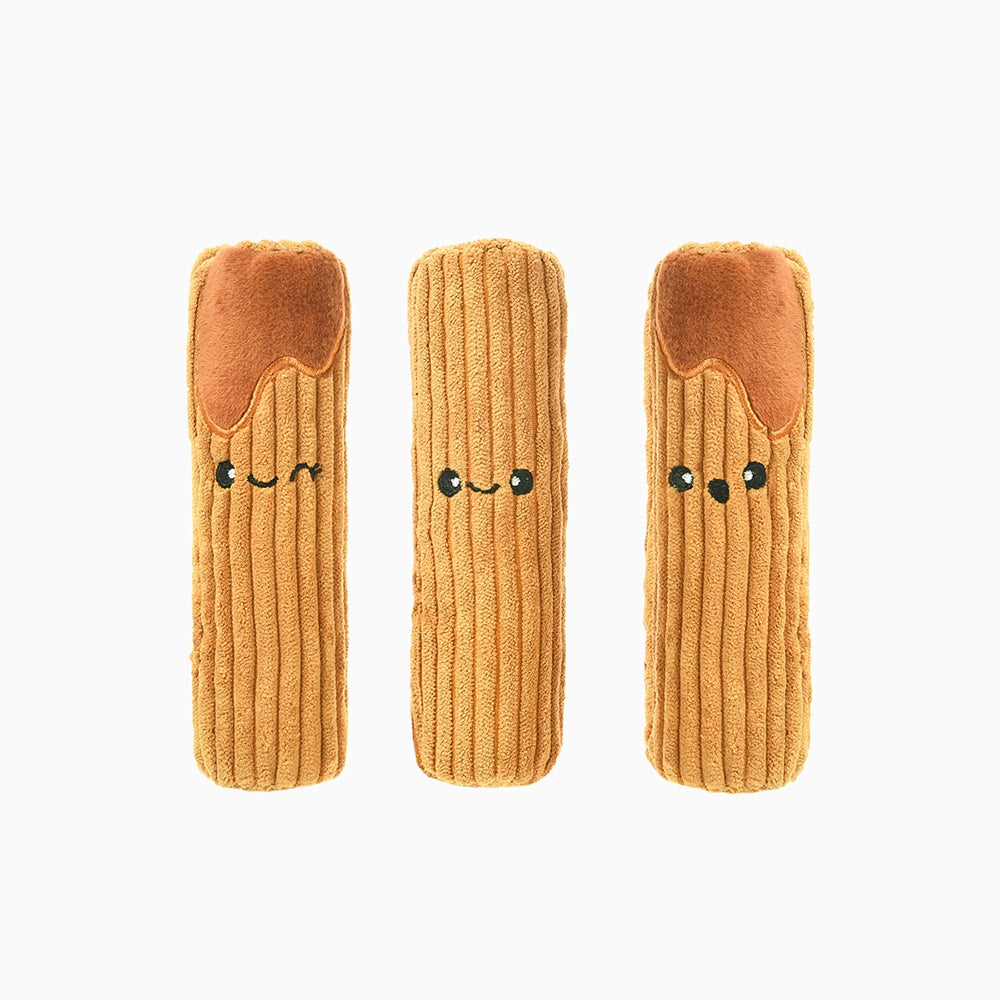 Three plush toys shaped like pasta with smiling faces on a white background
