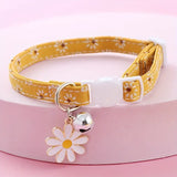 Yellow floral-patterned pet collar with a white flower charm and bell on a pink background