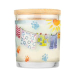 Candle with a design of clothes on a line and paw prints on a white background