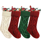 Four knitted Christmas stockings in red, green, and cream on a white background.