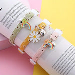 Three colorful bracelets with charms on an open book