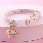 Pink pet collar with a rainbow and flower charm on a pink background